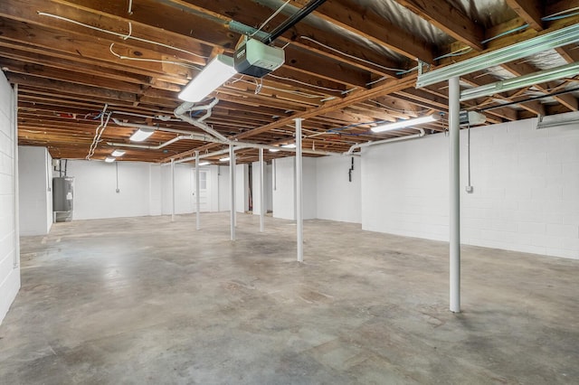 unfinished basement with electric water heater and concrete block wall