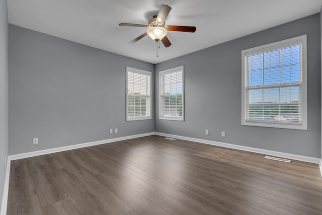 1493 Mcclardy Rd, Clarksville, TN 37042 - empty room with plenty of natural light, ceiling fan, dark wood finished floors, and baseboards