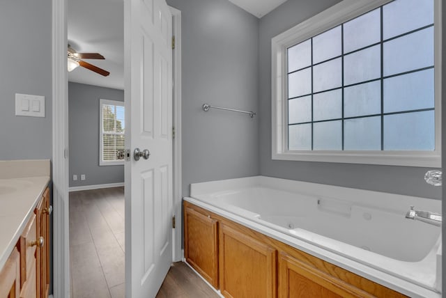 1493 Mcclardy Rd, Clarksville, TN 37042 - full bathroom featuring wood finished floors, a tub with jets, a ceiling fan, vanity, and baseboards