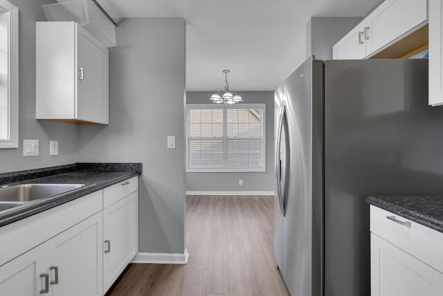 1493 Mcclardy Rd, Clarksville, TN 37042 - kitchen featuring freestanding refrigerator, baseboards, white cabinetry, and a chandelier