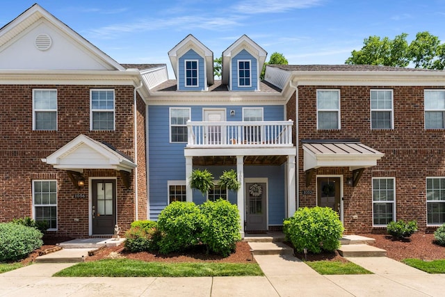 multi unit property featuring a balcony and brick siding