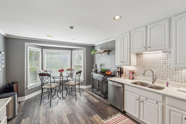 kitchen featuring stainless steel dishwasher, a sink, baseboards, ornamental molding, and tasteful backsplash