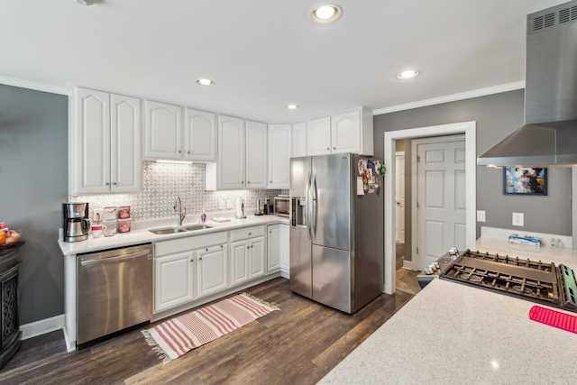 kitchen with appliances with stainless steel finishes, wall chimney range hood, a sink, dark wood finished floors, and white cabinets