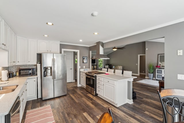 kitchen with appliances with stainless steel finishes, island range hood, ornamental molding, dark wood-type flooring, and recessed lighting