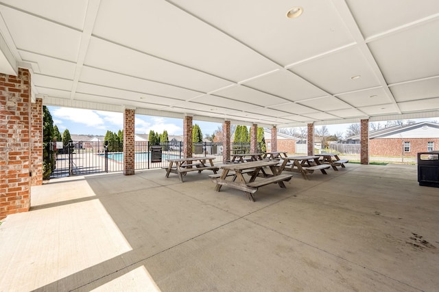 view of patio featuring fence, a community pool, and cooling unit