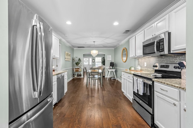 kitchen with appliances with stainless steel finishes, crown molding, white cabinetry, tasteful backsplash, and light stone counters