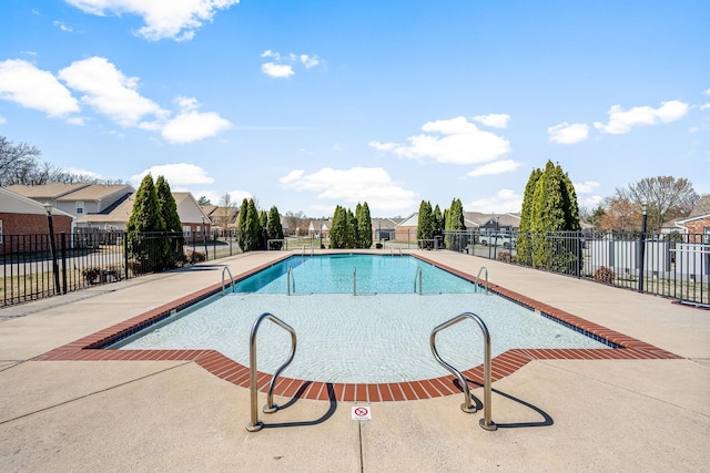 community pool featuring fence, a residential view, and a patio area