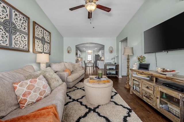 living area featuring arched walkways, ceiling fan, lofted ceiling, and dark wood-style floors