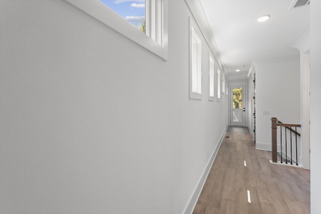 hall with wood finished floors, an upstairs landing, baseboards, and recessed lighting