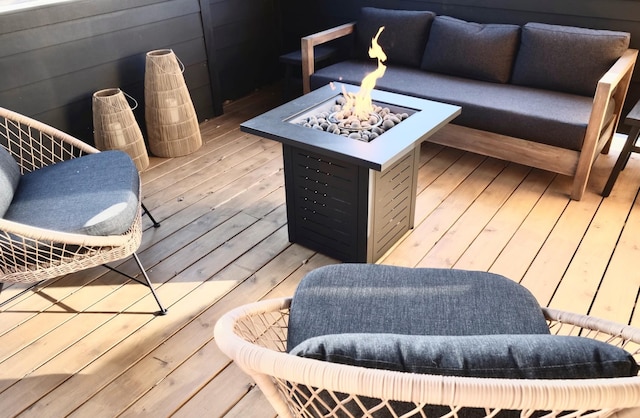 deck with an outdoor living space with a fire pit