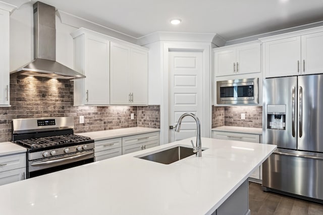 kitchen with stainless steel appliances, wall chimney range hood, a sink, light countertops, and backsplash