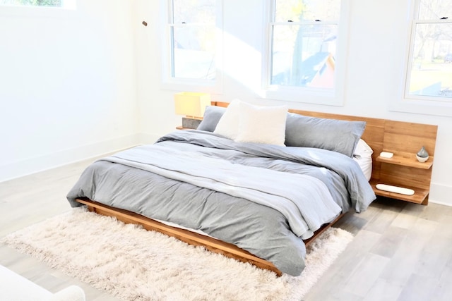 bedroom with wood finished floors and baseboards