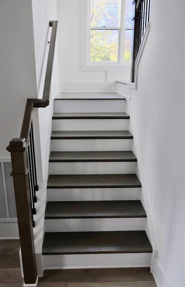 stairway featuring wood finished floors and baseboards
