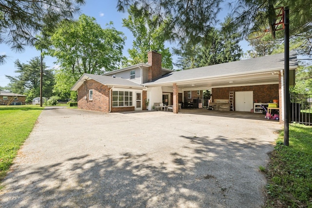 906 Temple Ct, Murfreesboro, TN 37130 - back of property featuring brick siding, a chimney, concrete driveway, and a carport