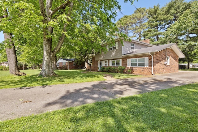 906 Temple Ct, Murfreesboro, TN 37130 - view of front of house featuring brick siding, a front yard, a chimney, and driveway