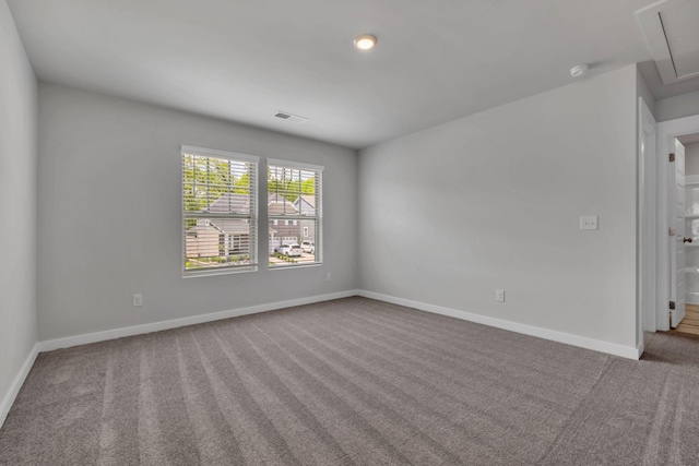 empty room with carpet flooring, attic access, baseboards, and a smoke detector