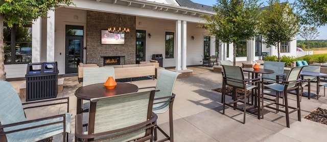 view of patio with outdoor dining space and an outdoor stone fireplace