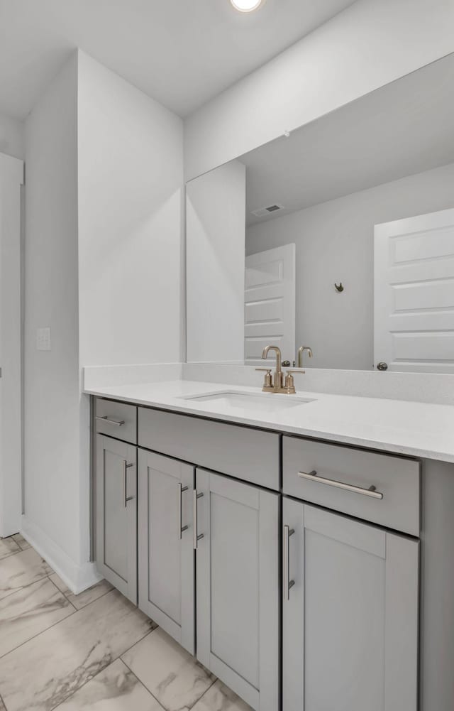 bathroom with marble finish flooring, vanity, and baseboards