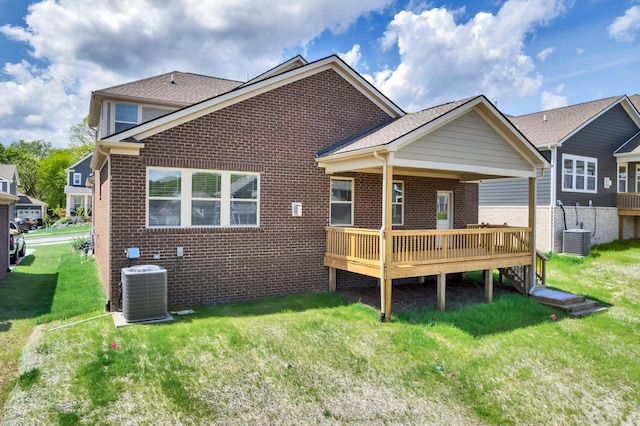 rear view of property featuring brick siding, central AC, and a lawn