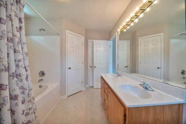 bathroom featuring shower / bath combination with curtain, baseboards, and double vanity
