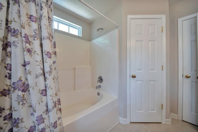 full bath featuring baseboards, tile patterned flooring, and shower / bathtub combination with curtain