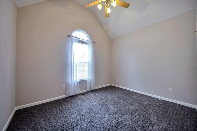 empty room with ceiling fan, vaulted ceiling, dark carpet, and baseboards
