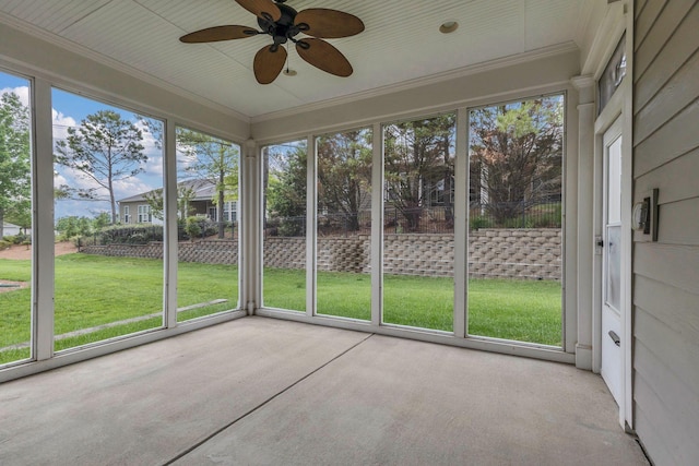 unfurnished sunroom with a ceiling fan and plenty of natural light