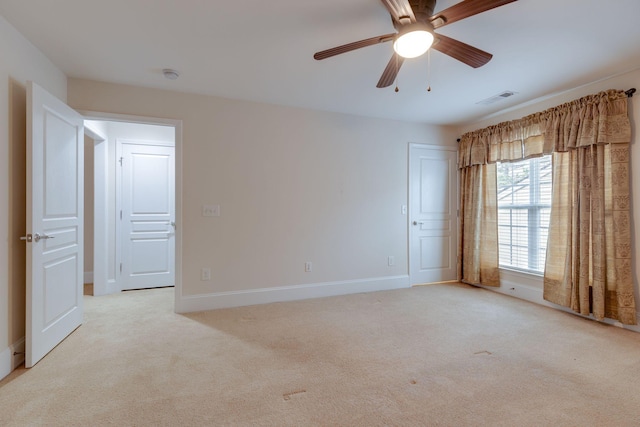 spare room featuring light colored carpet, baseboards, a ceiling fan, and a smoke detector