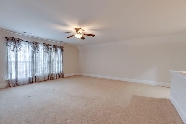 unfurnished room with a ceiling fan, light carpet, and baseboards