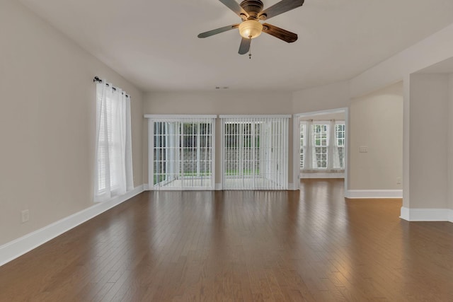 spare room featuring hardwood / wood-style floors, baseboards, and a ceiling fan