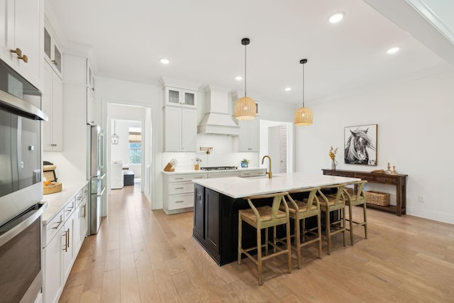 7214 Neills Branch Dr, College Grove, TN 37046 - kitchen featuring custom exhaust hood, a breakfast bar, appliances with stainless steel finishes, a center island with sink, and light countertops