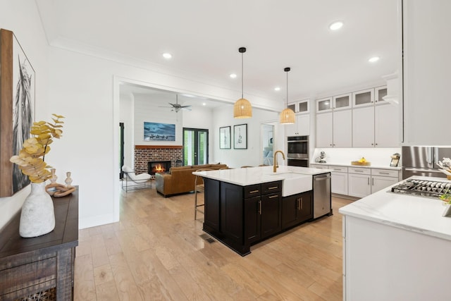 7214 Neills Branch Dr, College Grove, TN 37046 - kitchen with a brick fireplace, stainless steel appliances, open floor plan, a sink, and white cabinetry