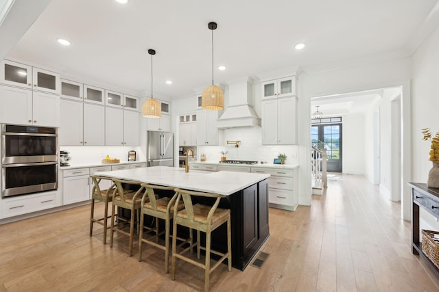 7214 Neills Branch Dr, College Grove, TN 37046 - kitchen with custom exhaust hood, appliances with stainless steel finishes, a kitchen bar, decorative backsplash, and a kitchen island with sink