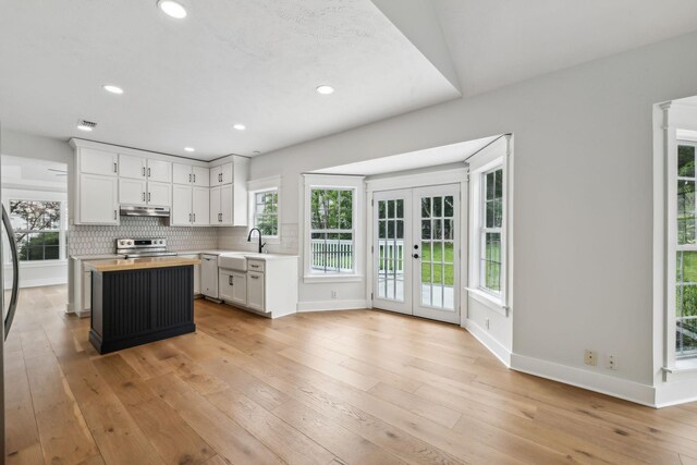 503 Mable Mason Cv, La Vergne, TN 37086 - kitchen with under cabinet range hood, wood counters, stainless steel electric stove, baseboards, and french doors
