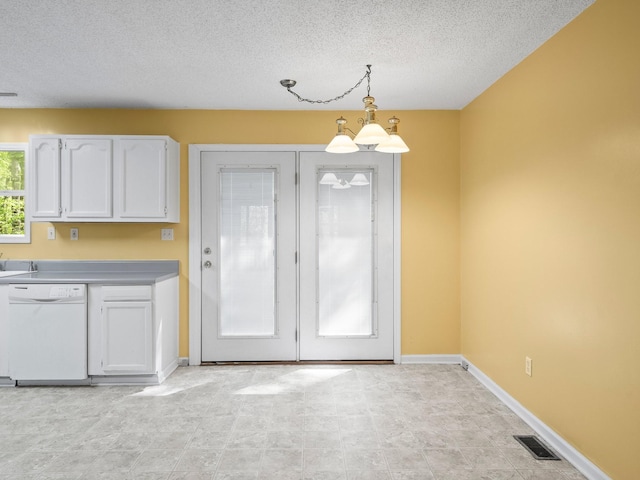 unfurnished dining area featuring a textured ceiling and baseboards