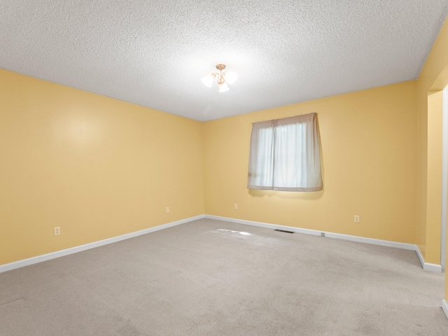 unfurnished room with baseboards, carpet, and a textured ceiling