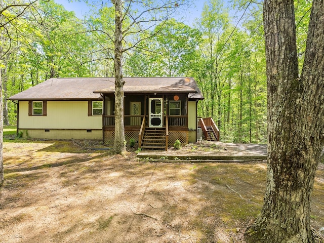 view of front of home with crawl space, stairs, and roof with shingles