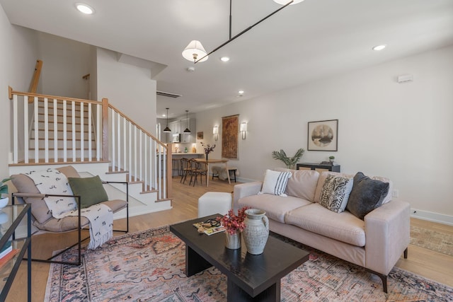 living area with stairs, wood finished floors, recessed lighting, and baseboards