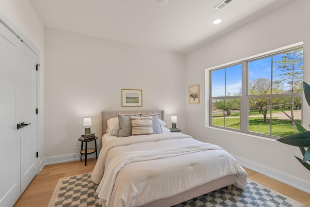bedroom featuring baseboards, light wood finished floors, and recessed lighting