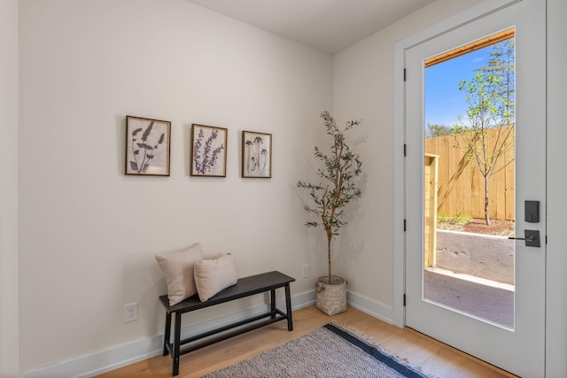 doorway to outside with wood finished floors and baseboards