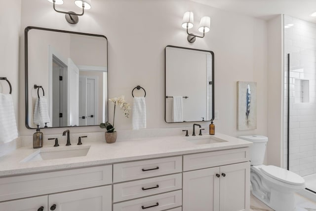full bath featuring toilet, a tile shower, and double vanity