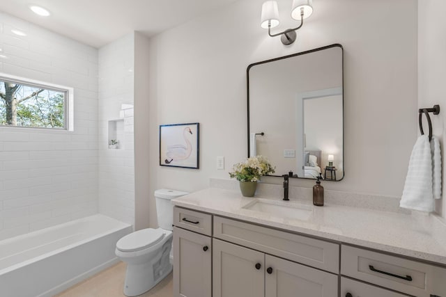 ensuite bathroom with toilet, vanity, and bathtub / shower combination