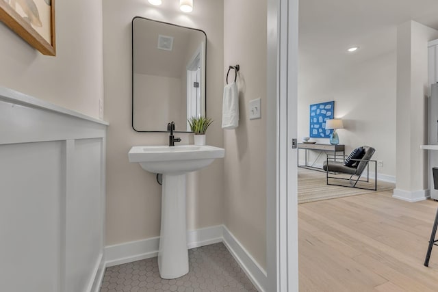bathroom with baseboards, wood finished floors, and recessed lighting