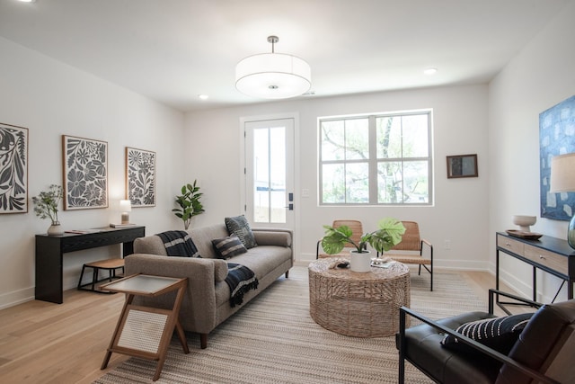 living area with light wood-type flooring, baseboards, and recessed lighting