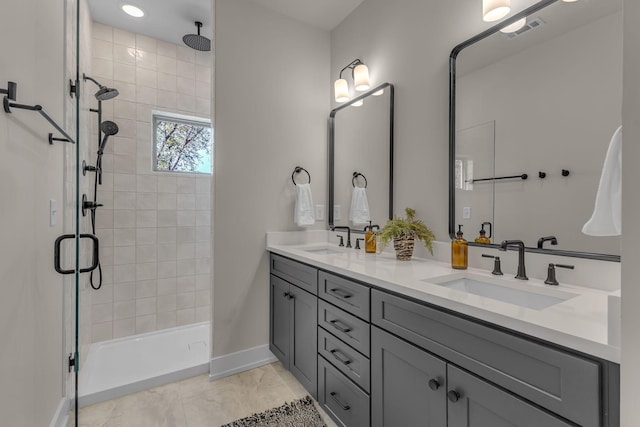 bathroom featuring a stall shower, baseboards, and double vanity