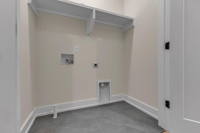 laundry area featuring electric dryer hookup, hookup for a washing machine, baseboards, and dark tile patterned flooring