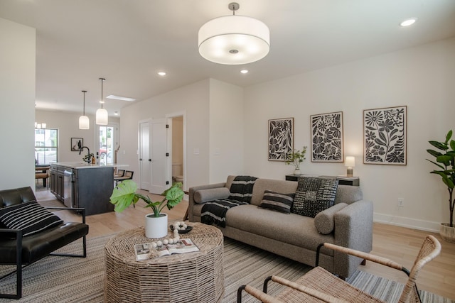 living area with light wood-style flooring, recessed lighting, and baseboards