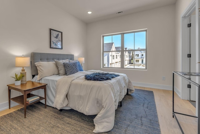 bedroom featuring light wood finished floors, recessed lighting, and baseboards
