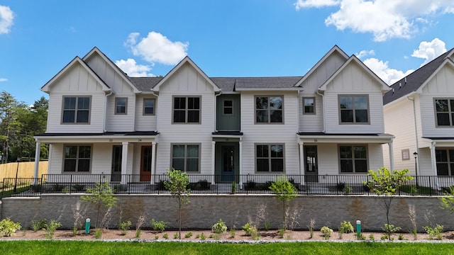 view of front facade featuring board and batten siding and fence