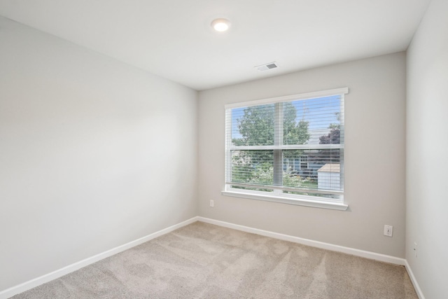 empty room with light colored carpet and baseboards